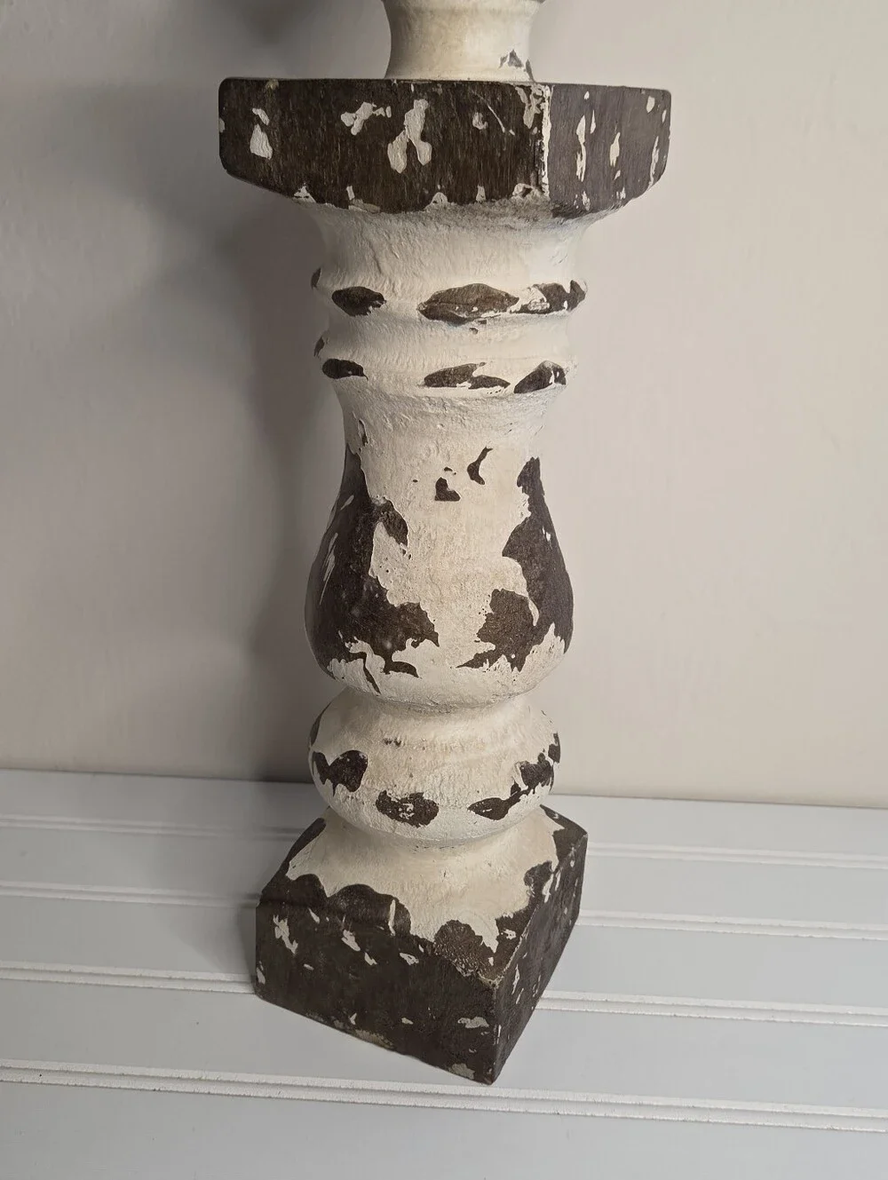 white and gold candlestick features a distressed finish and a lotus-shaped top